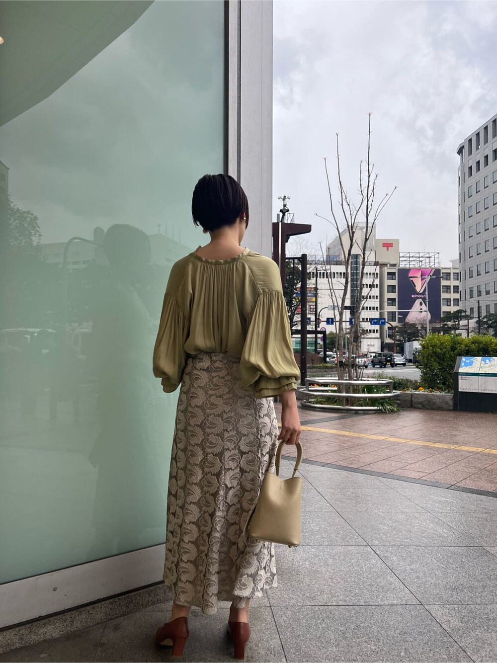 ホワイト系のハンドバッグ、ホワイト系のパンプス、グリーン系のシャツ/ブラウスを着用したレディースの春コーディネートの3枚目の写真