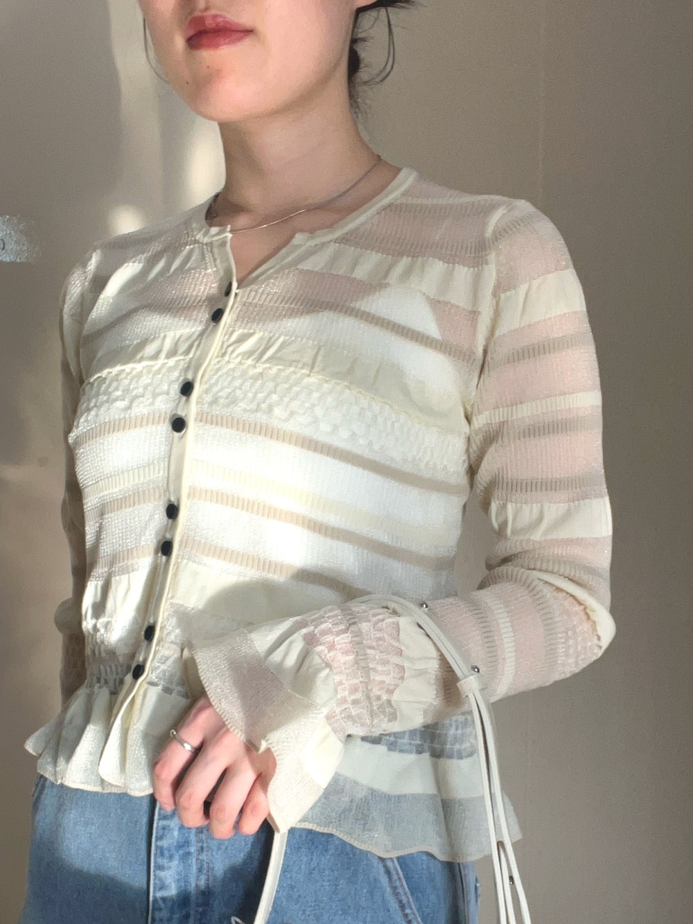 ホワイト系のニット/セーター、ブルー系のデニムパンツを着用したレディースの春コーディネートの3枚目の写真