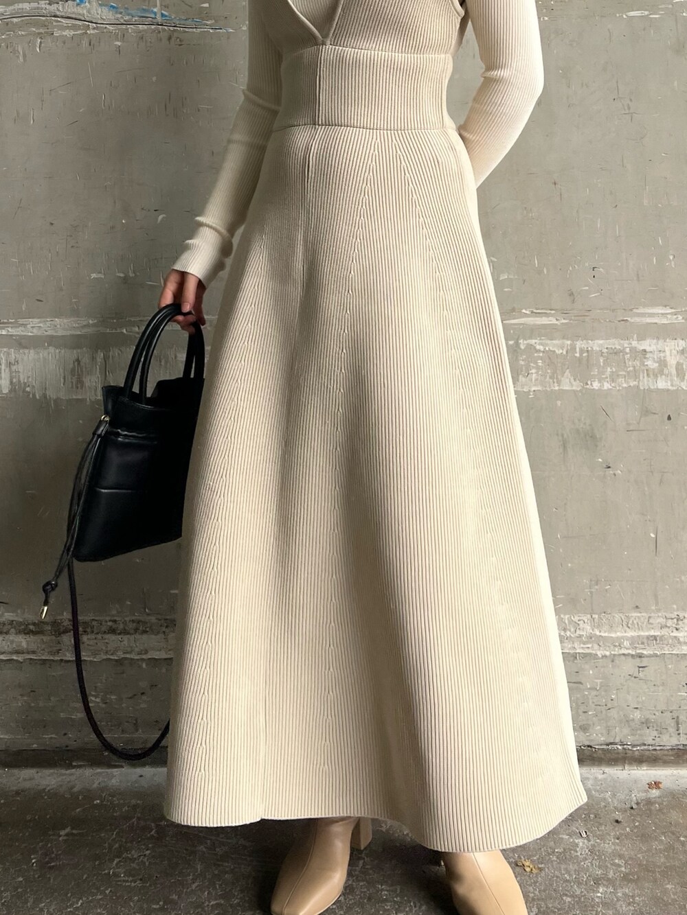 ベージュ系のブーツ、ブラック系のハンドバッグ、ホワイト系のニット/セーターを着用したレディースの秋コーディネートの9枚目の写真