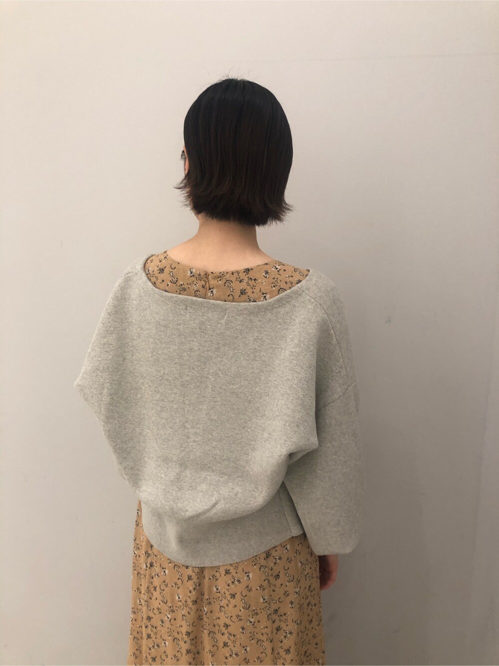 イエロー系のワンピース、ベージュ系のサンダル、グレー系のカーディガン/ボレロを着用したレディースの冬コーディネートの6枚目の写真