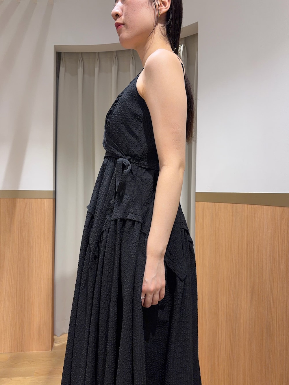 ブラック系のワンピース、ブラウン系のサンダル、ブラック系のハンドバッグを着用したレディースの夏コーディネートの5枚目の写真