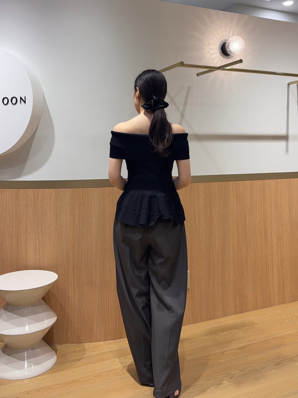 グレー系のその他パンツ、ブラック系のニット/セーター、ブラウン系のサンダルを着用したレディースの春コーディネートの3枚目の写真