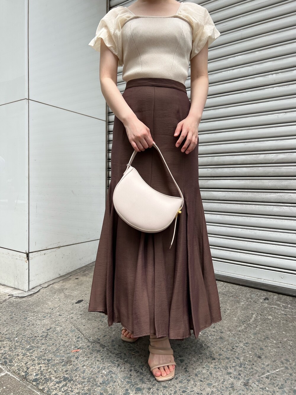 ベージュ系のサンダル、ブラウン系のスカート、ホワイト系のハンドバッグを着用したレディースの夏コーディネートの6枚目の写真
