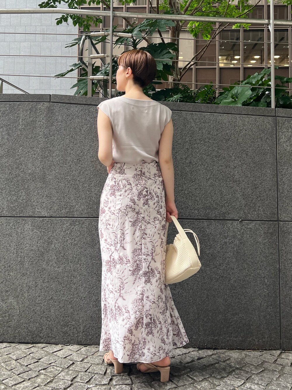 ベージュ系のサンダル、ベージュ系のニット/セーター、ブラウン系のスカートを着用したレディースの夏コーディネートの2枚目の写真