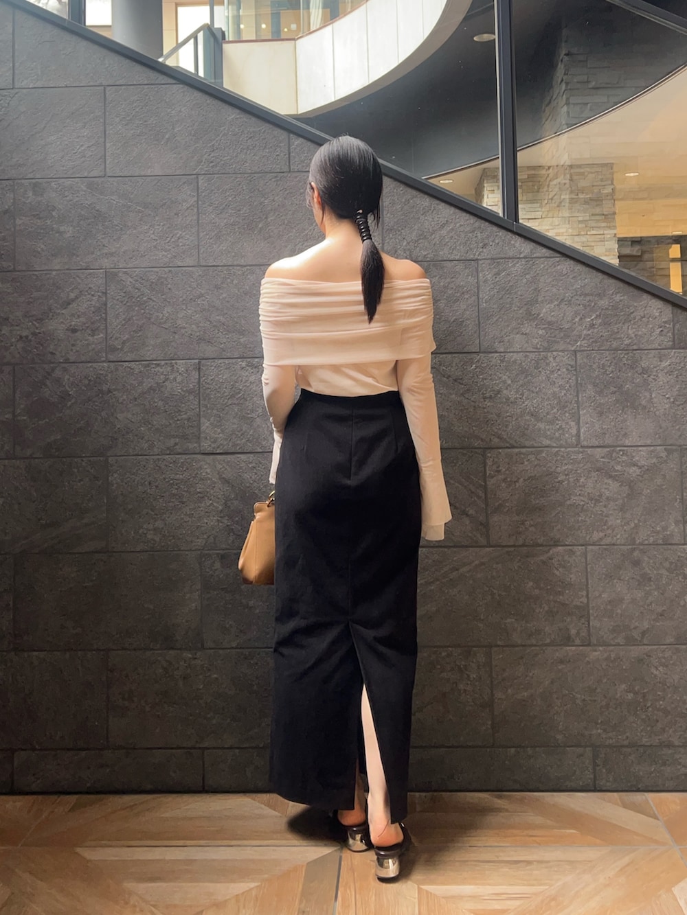 ホワイト系のTシャツ/カットソー、ブラック系のスカート、ブラウン系のパンプスを着用したレディースの秋コーディネートの3枚目の写真