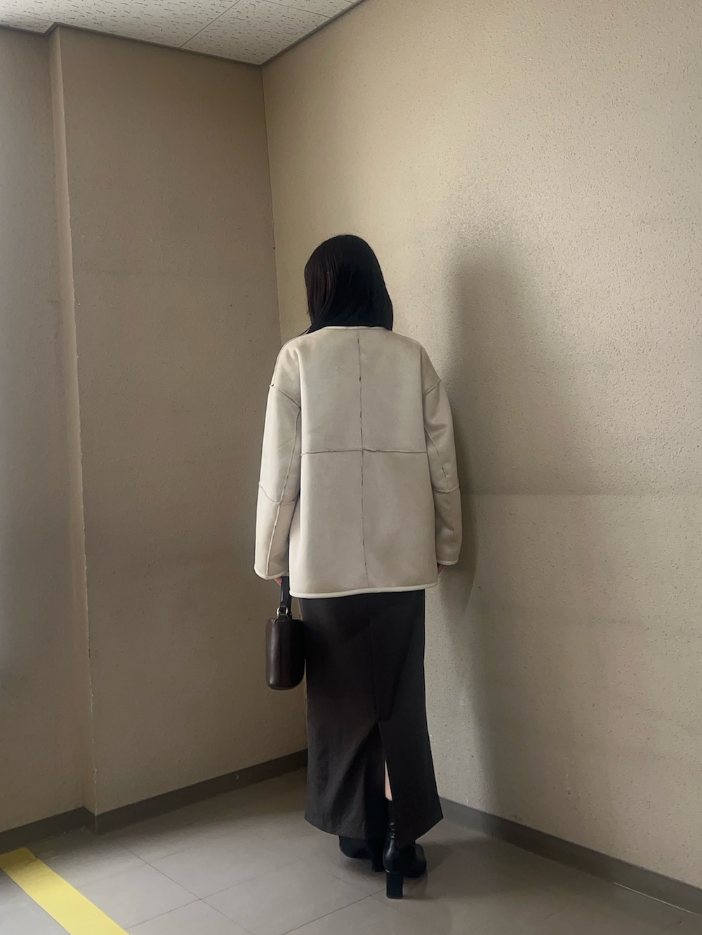 ホワイト系のブルゾン、ブラック系のブーツ、ブラック系のニット/セーターを着用したレディースの秋コーディネートの3枚目の写真