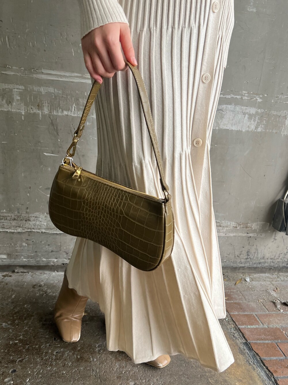 ベージュ系のブーツ、ホワイト系のワンピース、ベージュ系のハンドバッグを着用したレディースの冬コーディネートの9枚目の写真