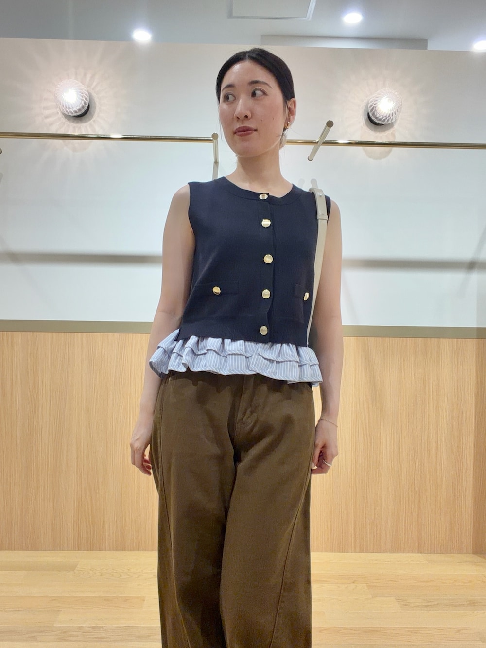 ブルー系のニット/セーター、ブラウン系のデニムパンツ、オレンジ系のサンダルを着用したレディースの夏コーディネートの4枚目の写真