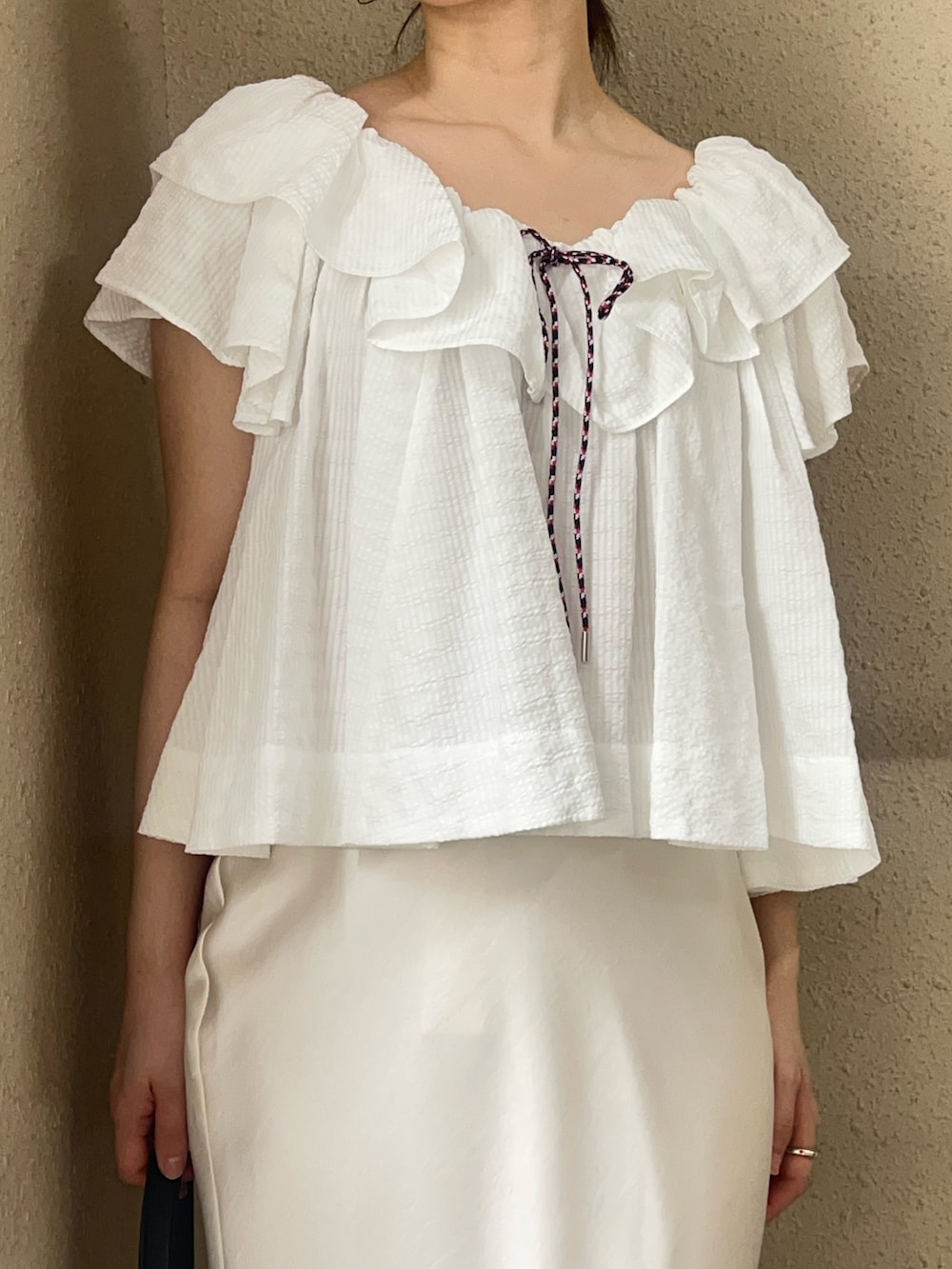 ホワイト系のシャツ/ブラウス、ホワイト系のスカート、ブラック系のパンプスを着用したレディースの春コーディネートの4枚目の写真