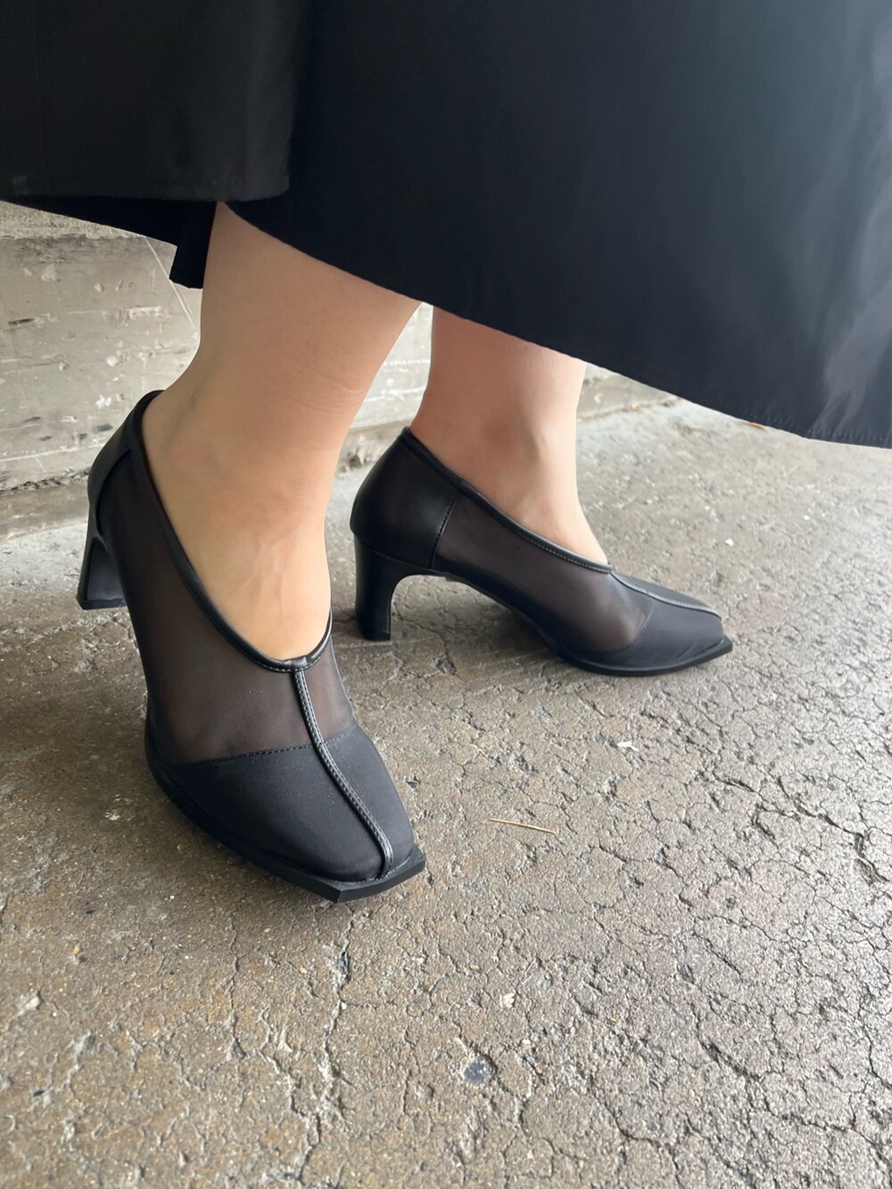 ホワイト系のハンドバッグ、ブラック系のワンピース、ブラック系のパンプスを着用したレディースの秋コーディネートの9枚目の写真