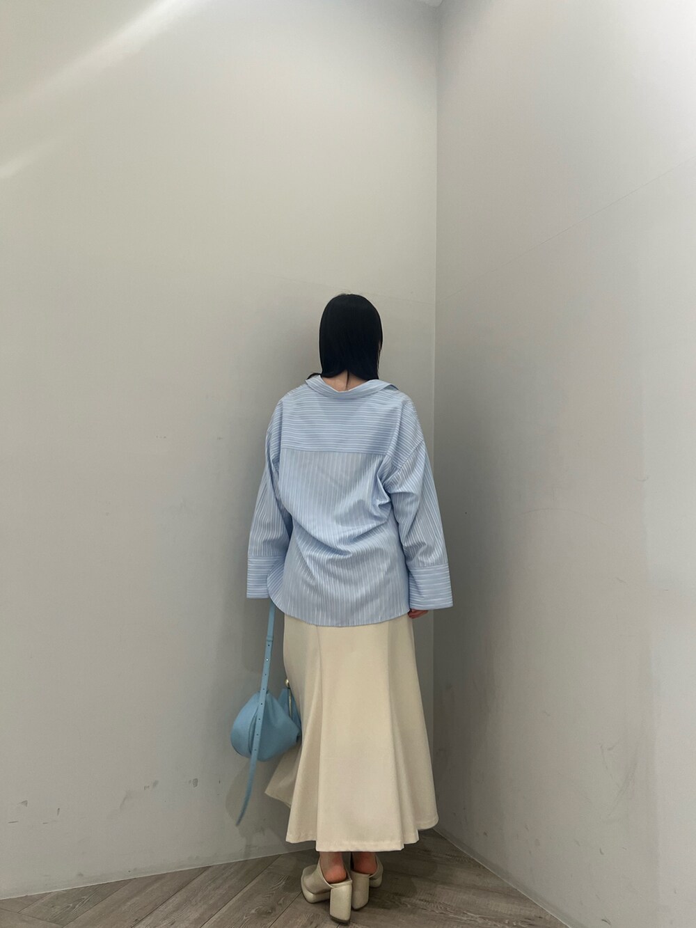 ブルー系のシャツ/ブラウス、ホワイト系のサンダル、ブルー系のショルダーバッグを着用したレディースの春コーディネートの3枚目の写真