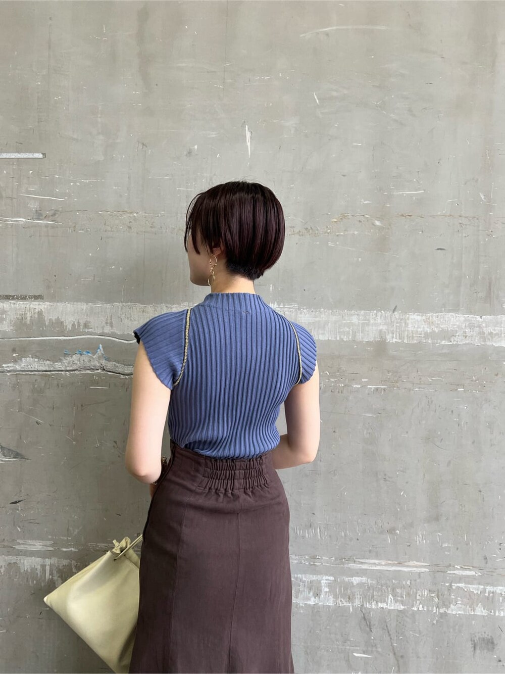 ホワイト系のハンドバッグ、レッド系のサンダル、ブラウン系のスカートを着用したレディースの夏コーディネートの6枚目の写真