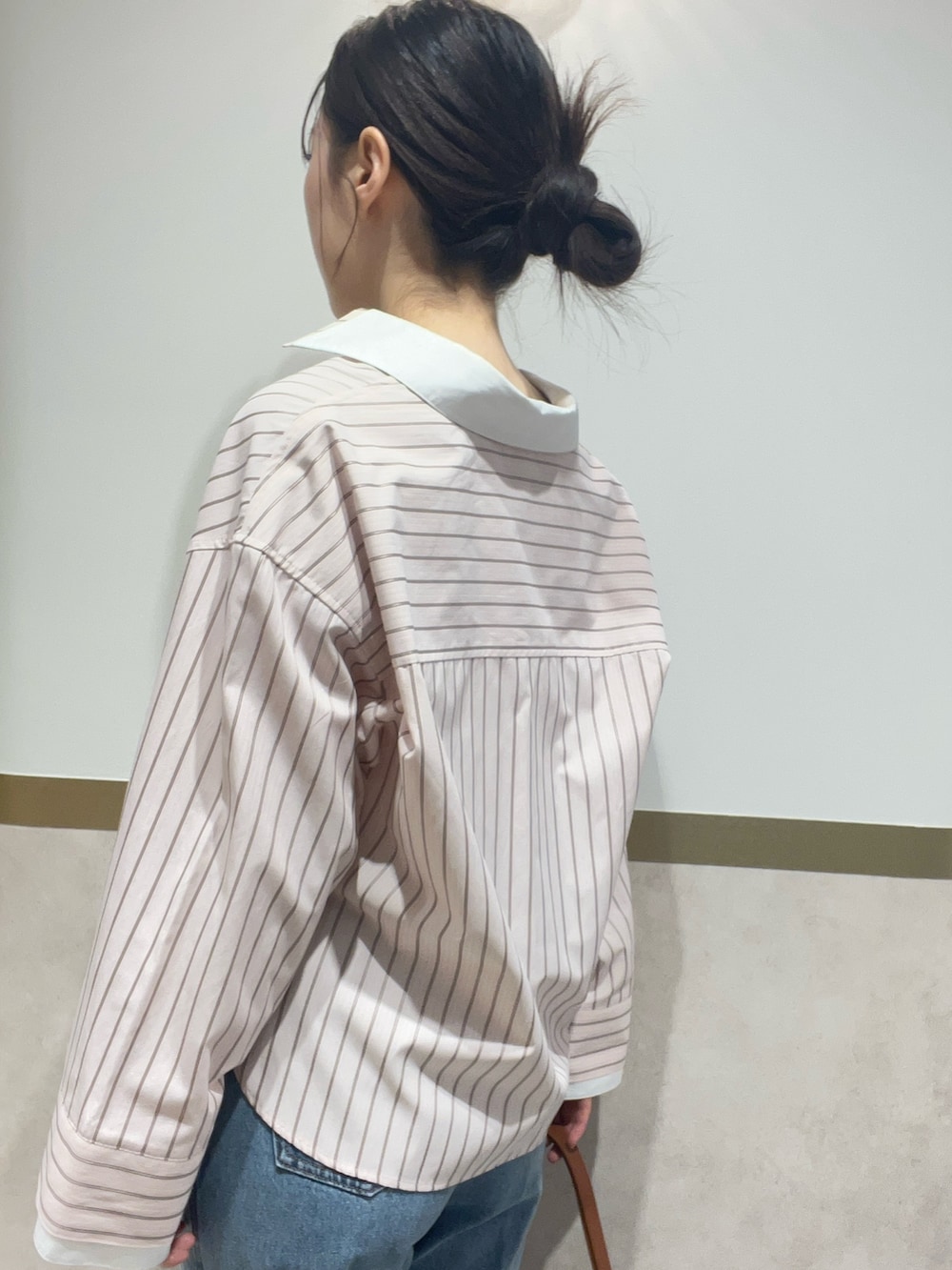 ピンク系のシャツ/ブラウス、ブルー系のデニムパンツ、ブラウン系のハンドバッグを着用したレディースの春コーディネートの5枚目の写真