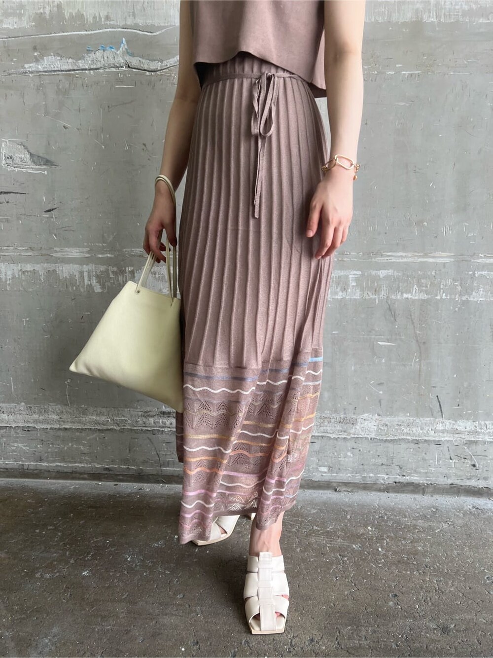 ホワイト系のハンドバッグ、ホワイト系のサンダル、ブラウン系のワンピースを着用したレディースの夏コーディネートの8枚目の写真