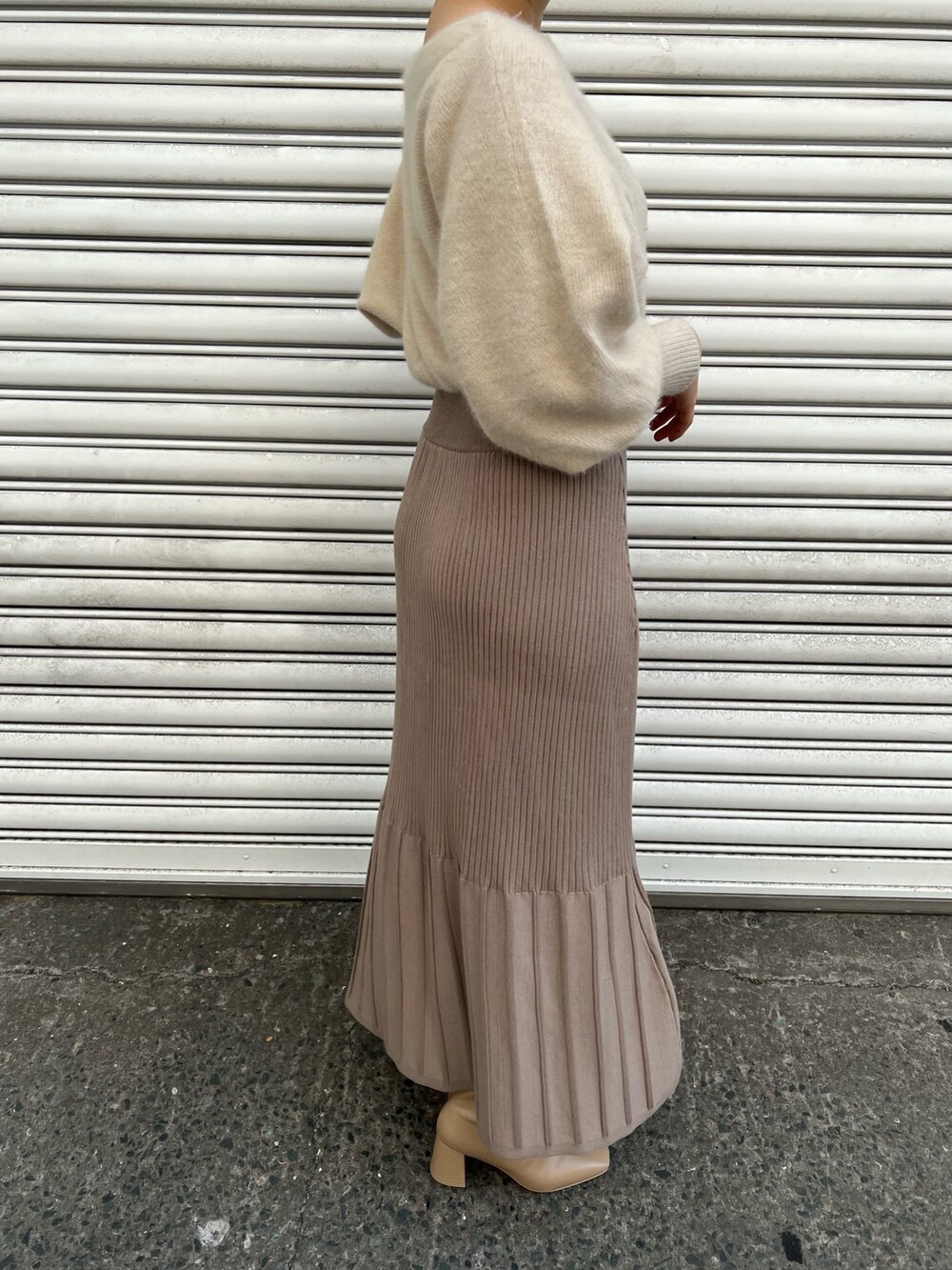 ピンク系のノーカラーコート、ホワイト系のワンピース、ベージュ系のブーツを着用したレディースの秋コーディネートの10枚目の写真