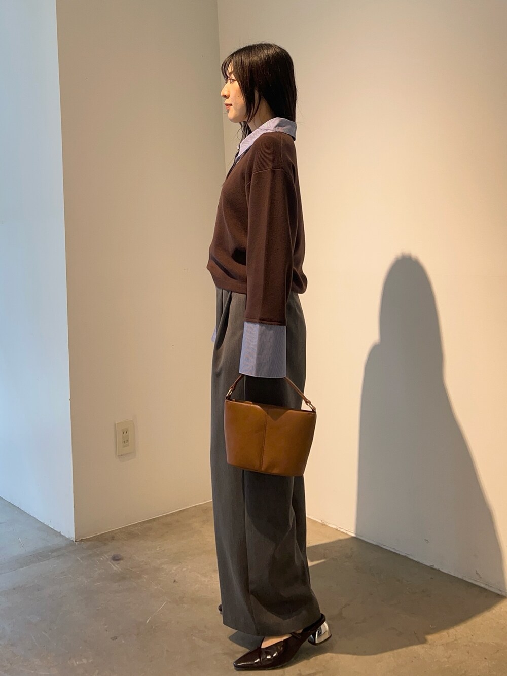 グレー系のその他パンツ、ブラウン系のニット/セーター、イエロー系のハンドバッグを着用したレディースの秋コーディネートの2枚目の写真