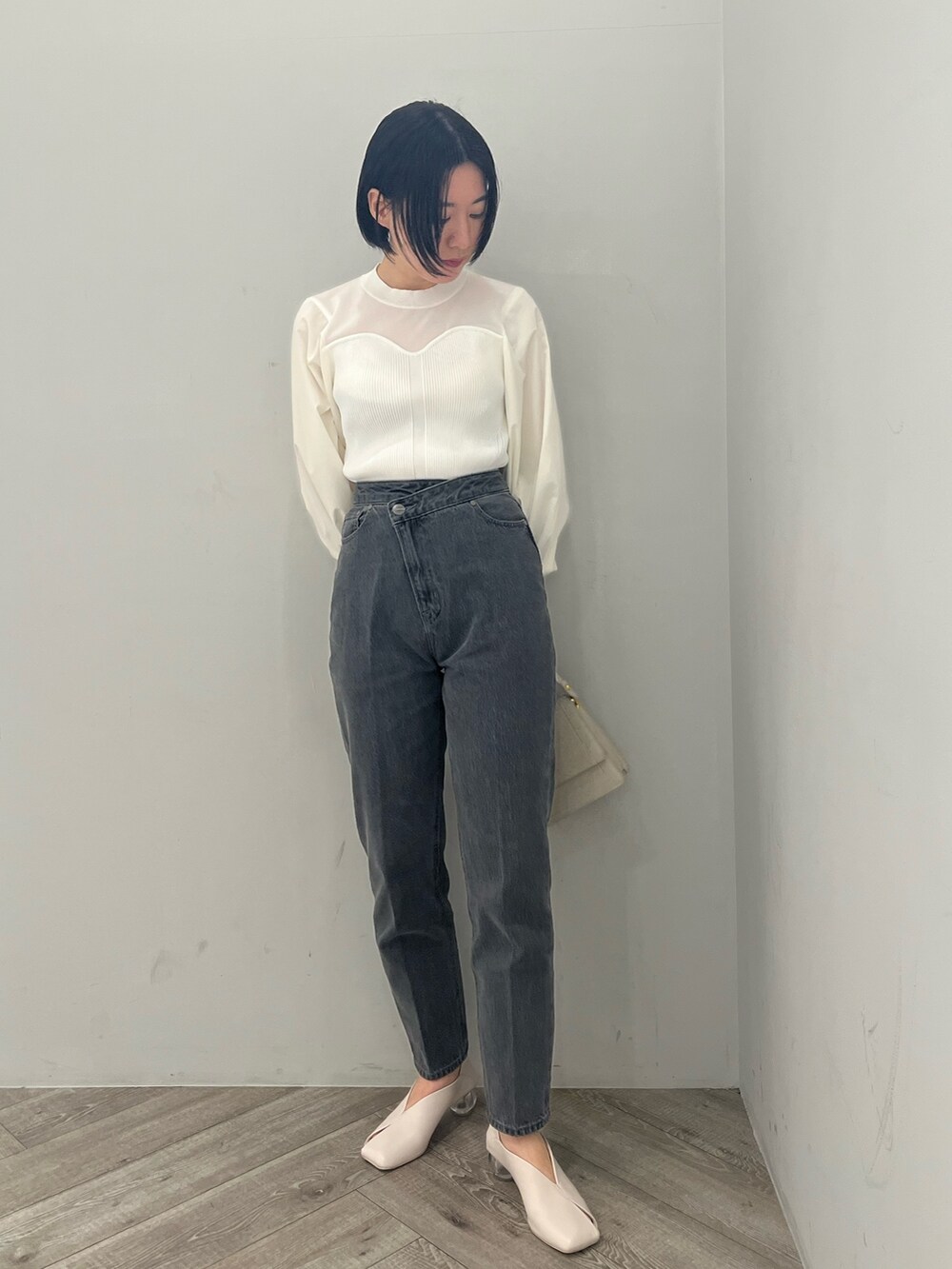 ホワイト系のトレンチコート、ホワイト系のニット/セーター、ブラック系のデニムパンツを着用したレディースの冬コーディネートの6枚目の写真