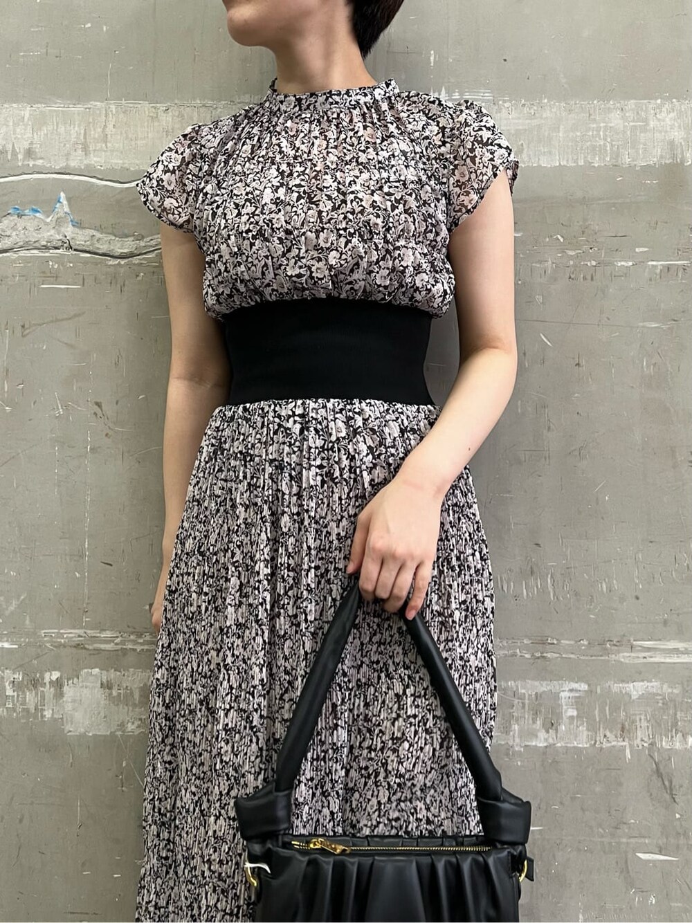 ブラウン系のパンプス、ブラック系のワンピース、ブラック系のハンドバッグを着用したレディースの夏コーディネートの6枚目の写真