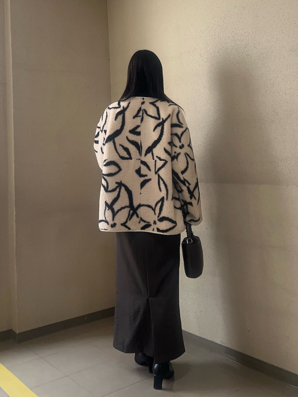 ブラック系のブーツ、ホワイト系のブルゾン、ブラック系のニット/セーターを着用したレディースの秋コーディネートの3枚目の写真