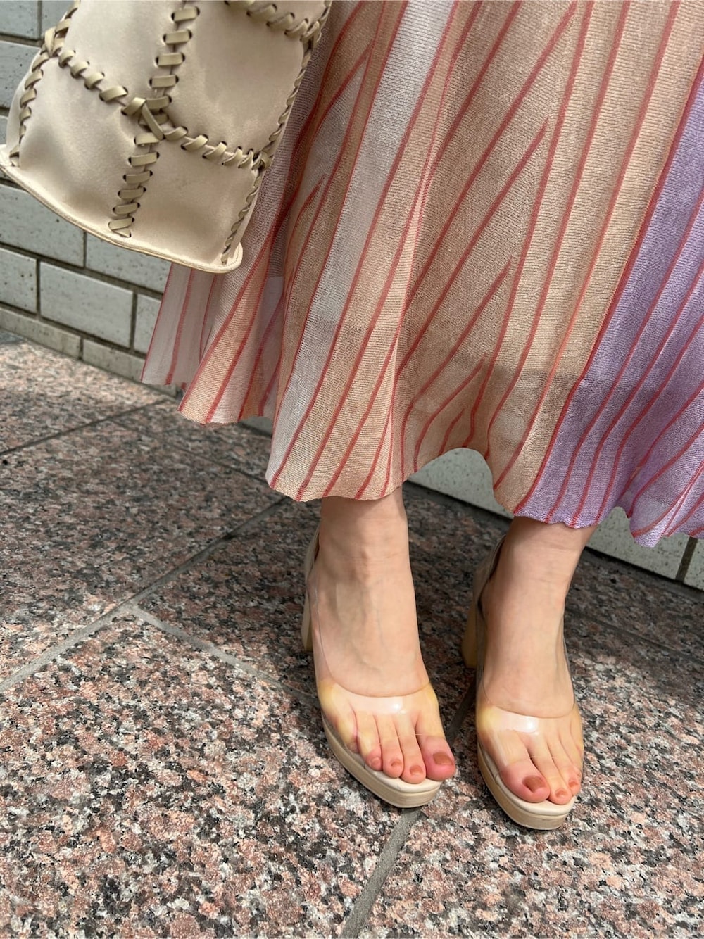 オレンジ系のスカート、その他のパンプス、ホワイト系のショルダーバッグを着用したレディースの春コーディネートの6枚目の写真