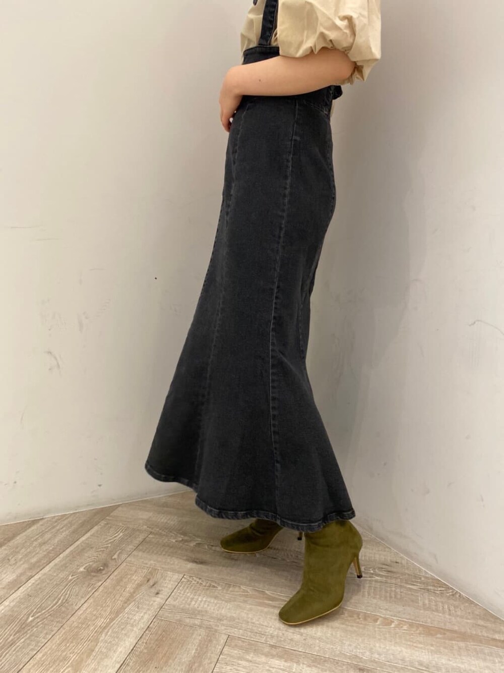 ベージュ系のシャツ/ブラウス、ブラック系のスカート、ベージュ系のブーツを着用したレディースの夏コーディネートの6枚目の写真