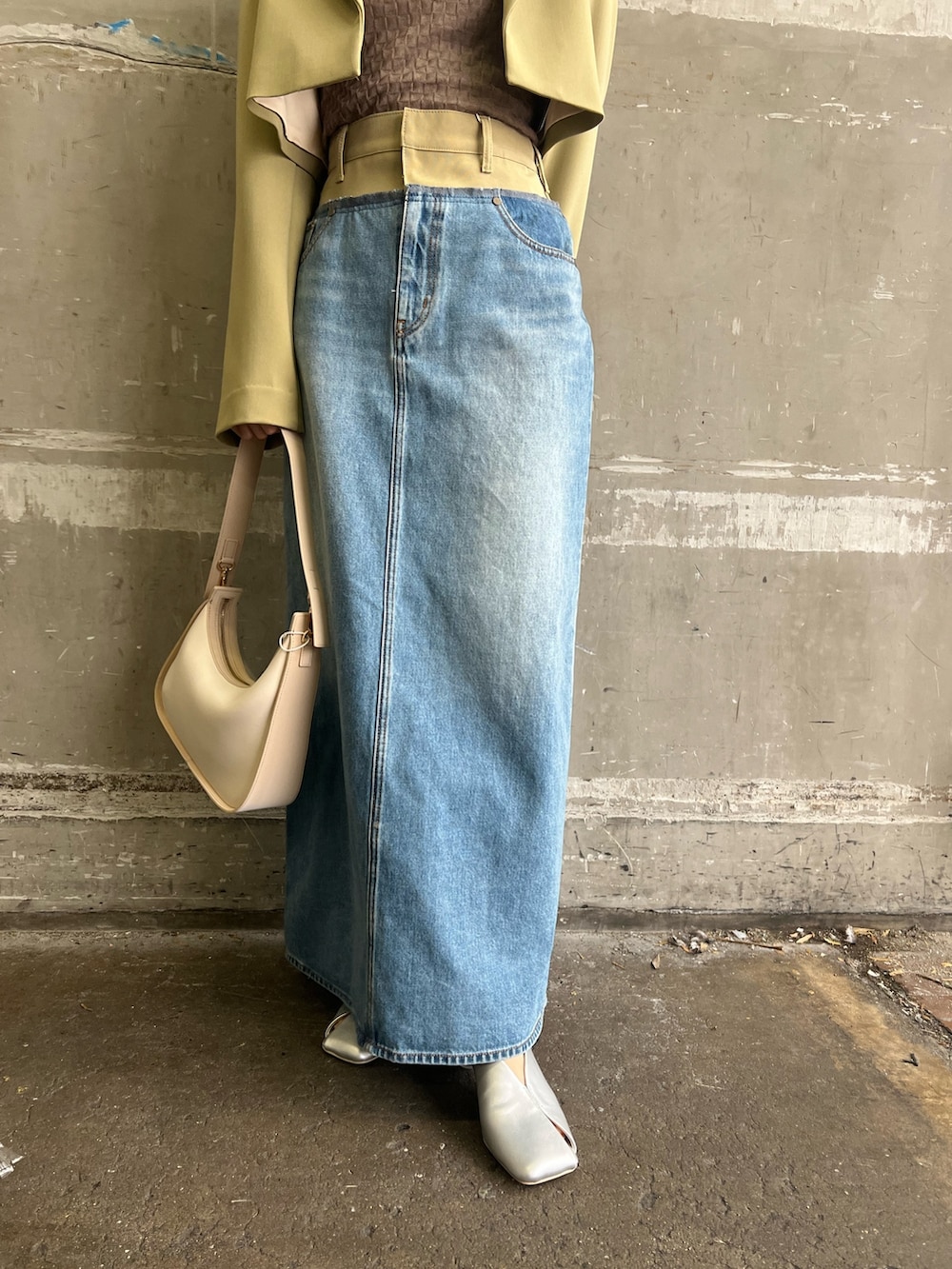 シルバー系のパンプス、グリーン系のテーラードジャケット、グリーン系のデニムスカートを着用したレディースの冬コーディネートの5枚目の写真