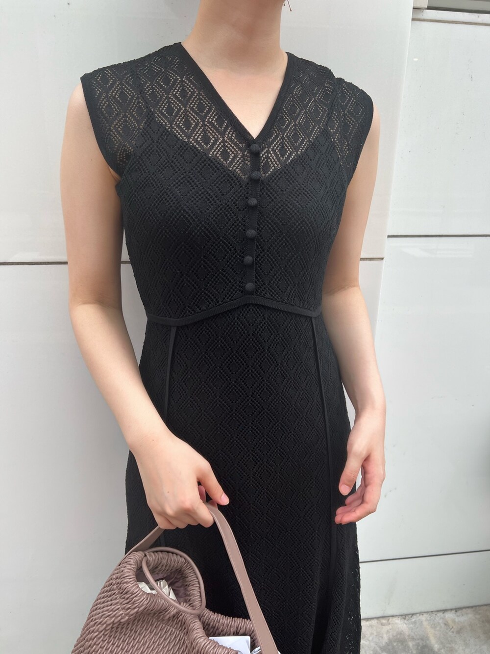 ベージュ系のサンダル、ホワイト系のハンドバッグ、ブラック系のワンピースを着用したレディースの夏コーディネートの5枚目の写真