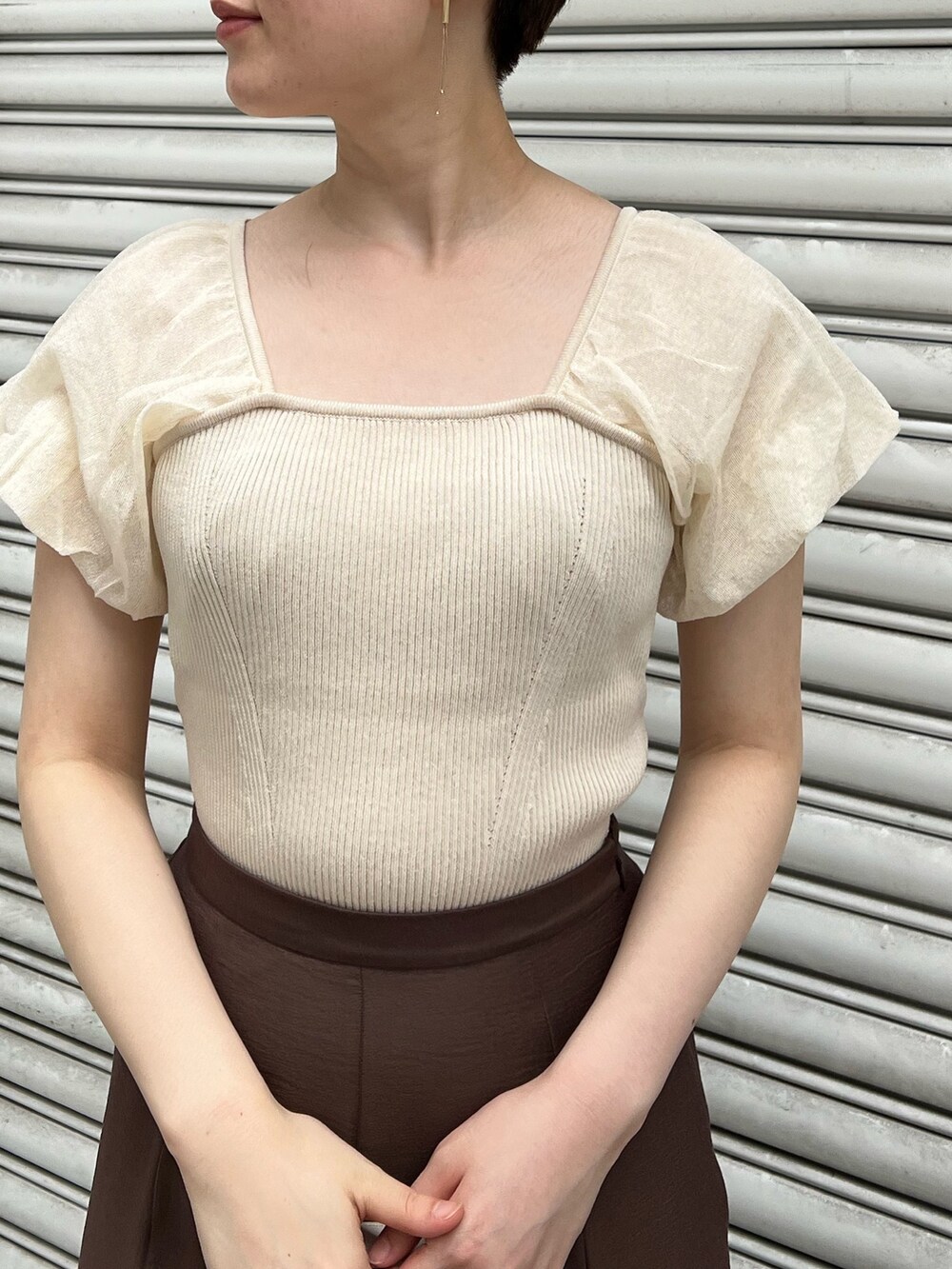 ベージュ系のサンダル、ブラウン系のスカート、ホワイト系のハンドバッグを着用したレディースの夏コーディネートの5枚目の写真