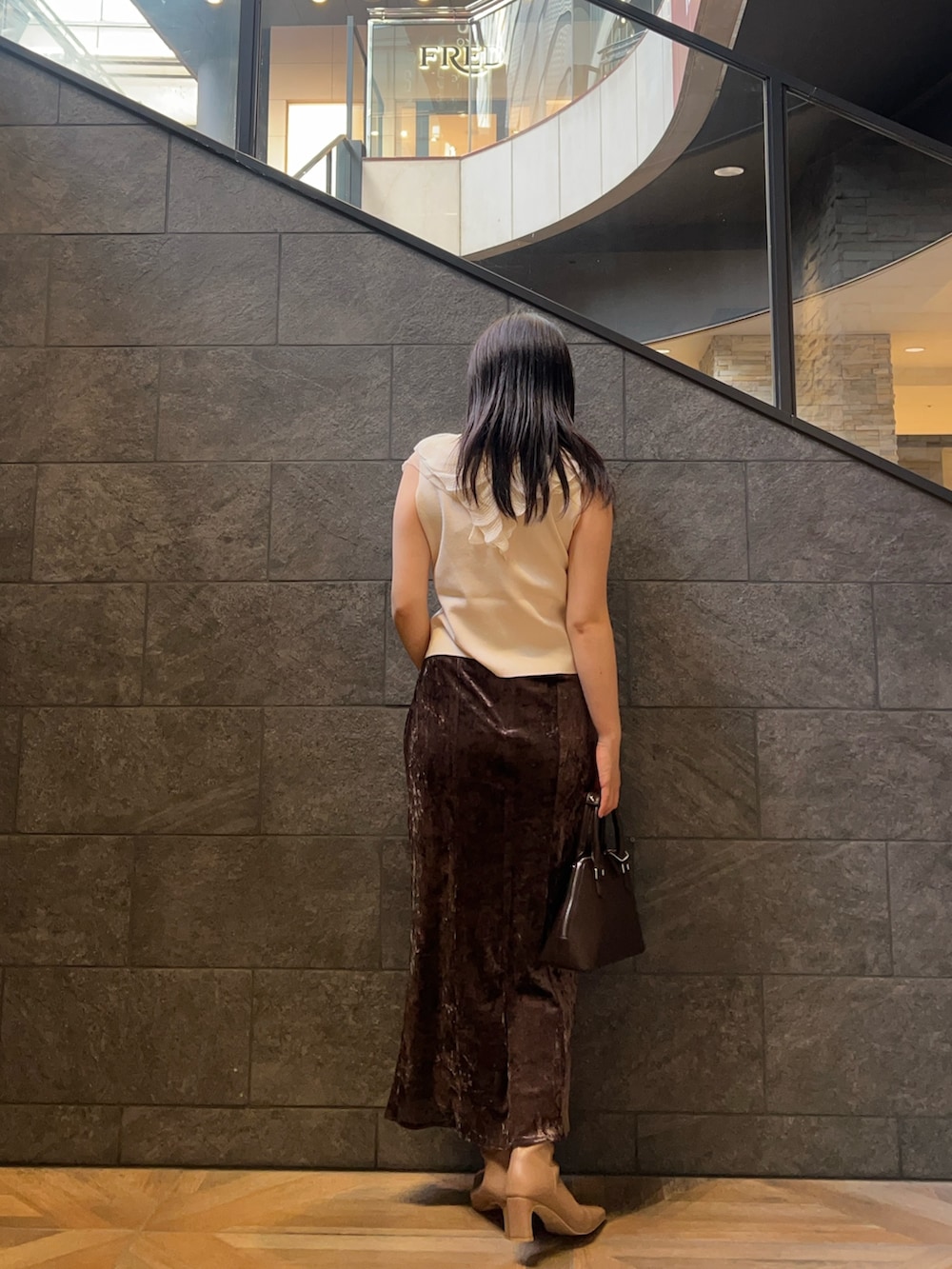 ブラウン系のボストンバッグ、ホワイト系のニット/セーター、ベージュ系のブーツを着用したレディースの秋コーディネートの3枚目の写真