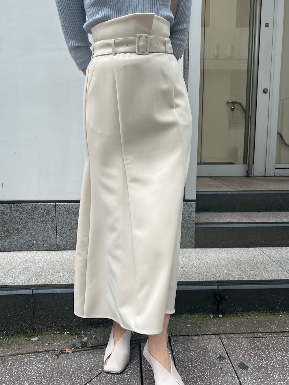 ホワイト系のパンプス、ベージュ系のハンドバッグ、ブルー系のニット/セーターを着用したレディースの春コーディネートの5枚目の写真