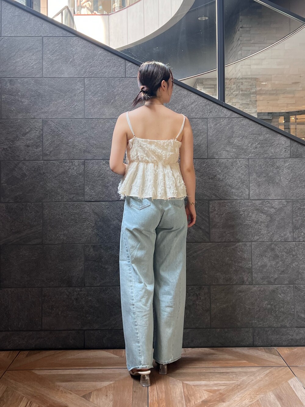 ホワイト系のサンダル、ホワイト系のキャミソール、ブルー系のデニムパンツを着用したレディースの夏コーディネートの2枚目の写真