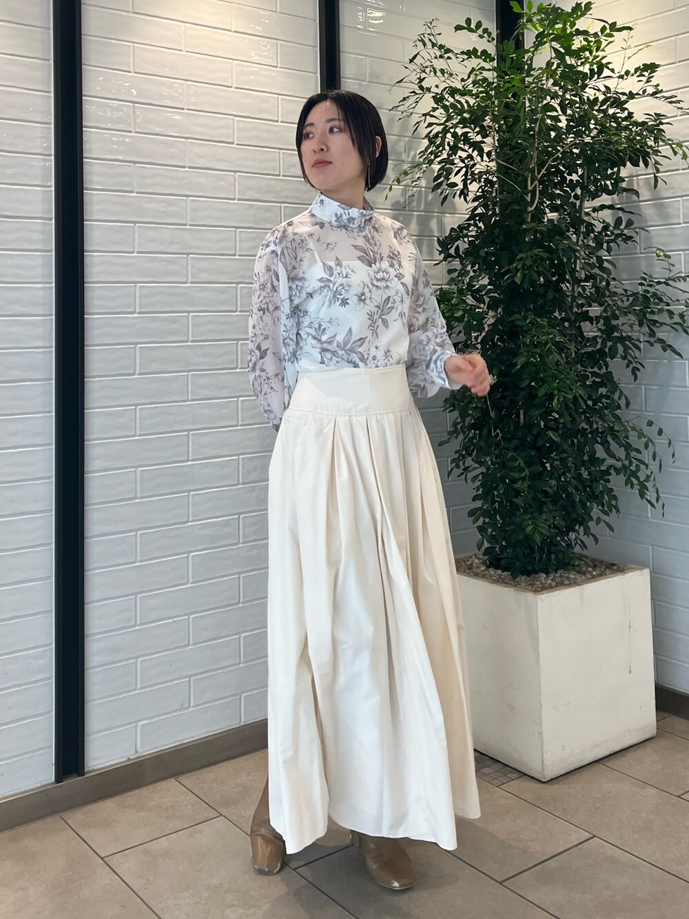 ホワイト系のスカート、ベージュ系のブーツ、ブラウン系のシャツ/ブラウスを着用したレディースの冬コーディネートの3枚目の写真