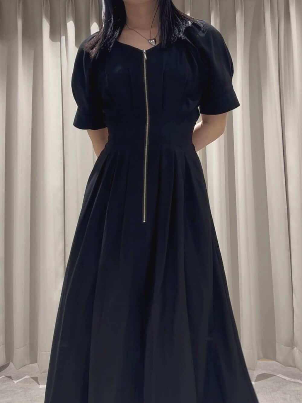 ホワイト系のサンダル、ブラック系のワンピースを着用したレディースの春コーディネートの4枚目の写真