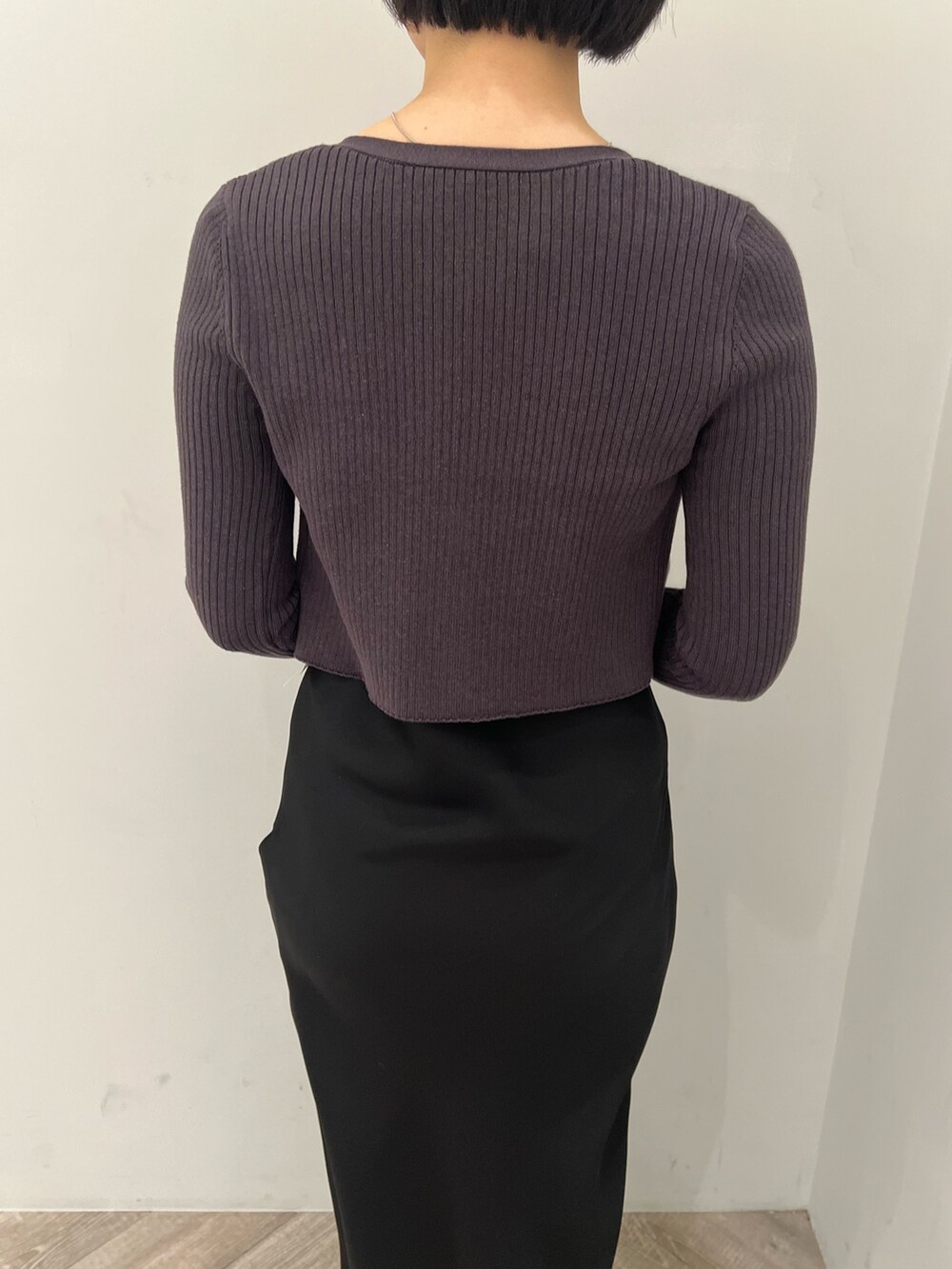 ブラック系のハンドバッグ、シルバー系のパンプス、ブラック系のワンピースを着用したレディースの冬コーディネートの4枚目の写真