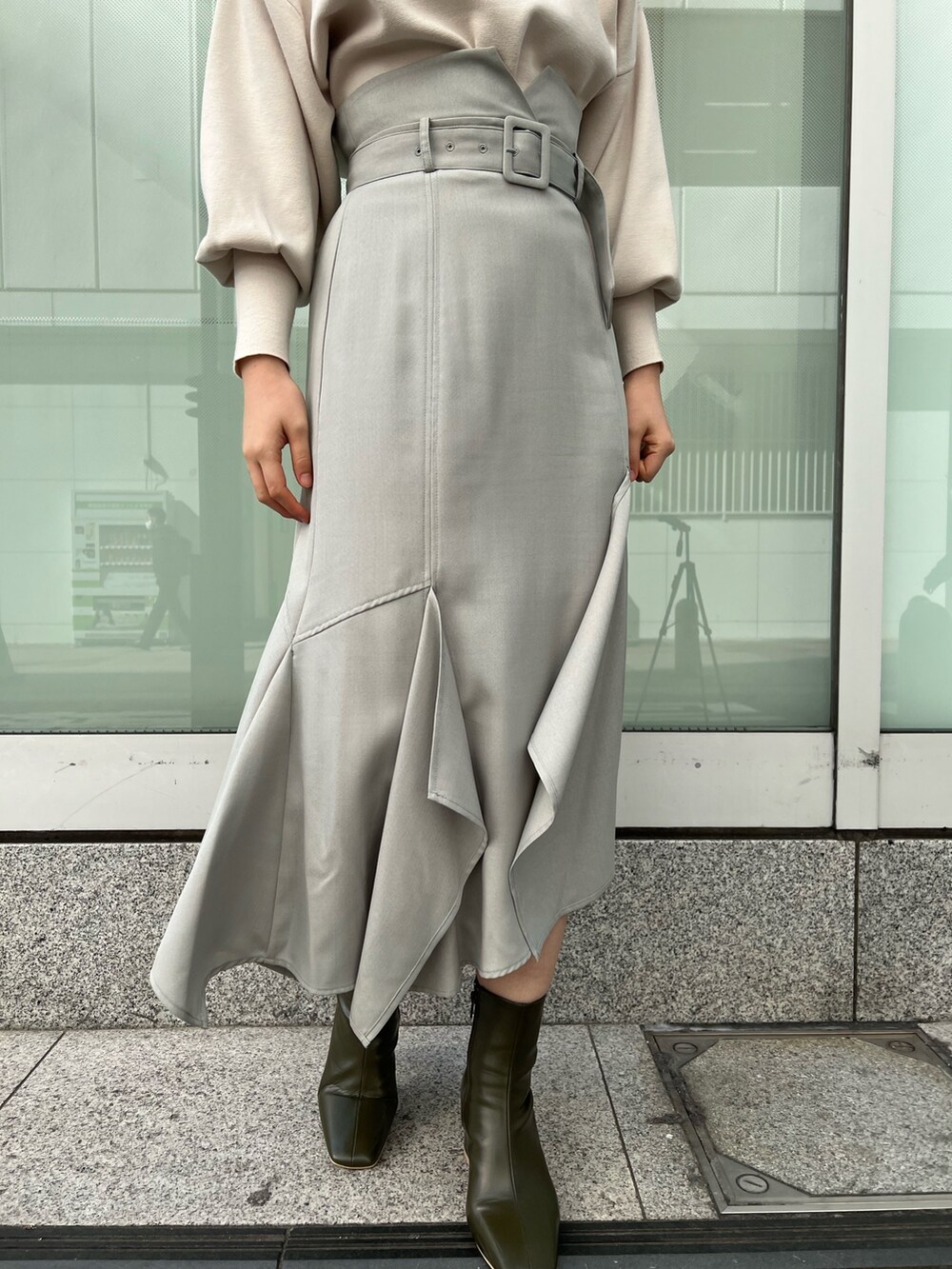 ベージュ系のブーツ、グリーン系のスカート、ホワイト系のニット/セーターを着用したレディースの冬コーディネートの6枚目の写真