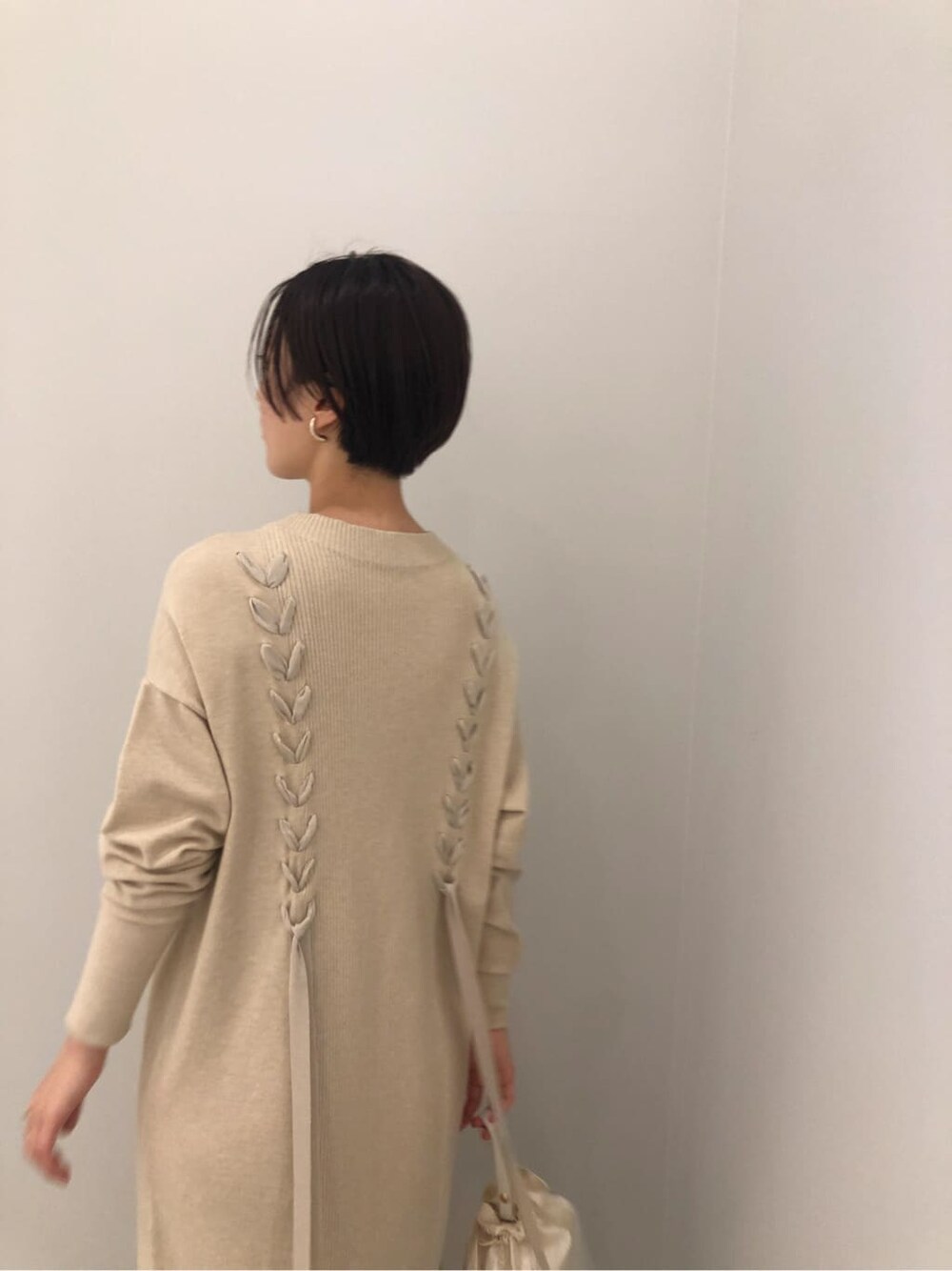 ホワイト系のワンピース、ホワイト系のハンドバッグ、ベージュ系のその他シューズを着用したレディースの秋コーディネートの4枚目の写真