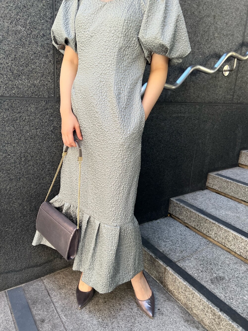 ブラック系のその他アウター、シルバー系のパンプス、グリーン系のドレスを着用したレディースの秋コーディネートの7枚目の写真