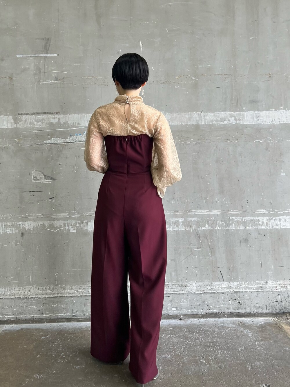 ホワイト系のノーカラーコート、シルバー系のハンドバッグ、シルバー系のパンプスを着用したレディースの冬コーディネートの4枚目の写真