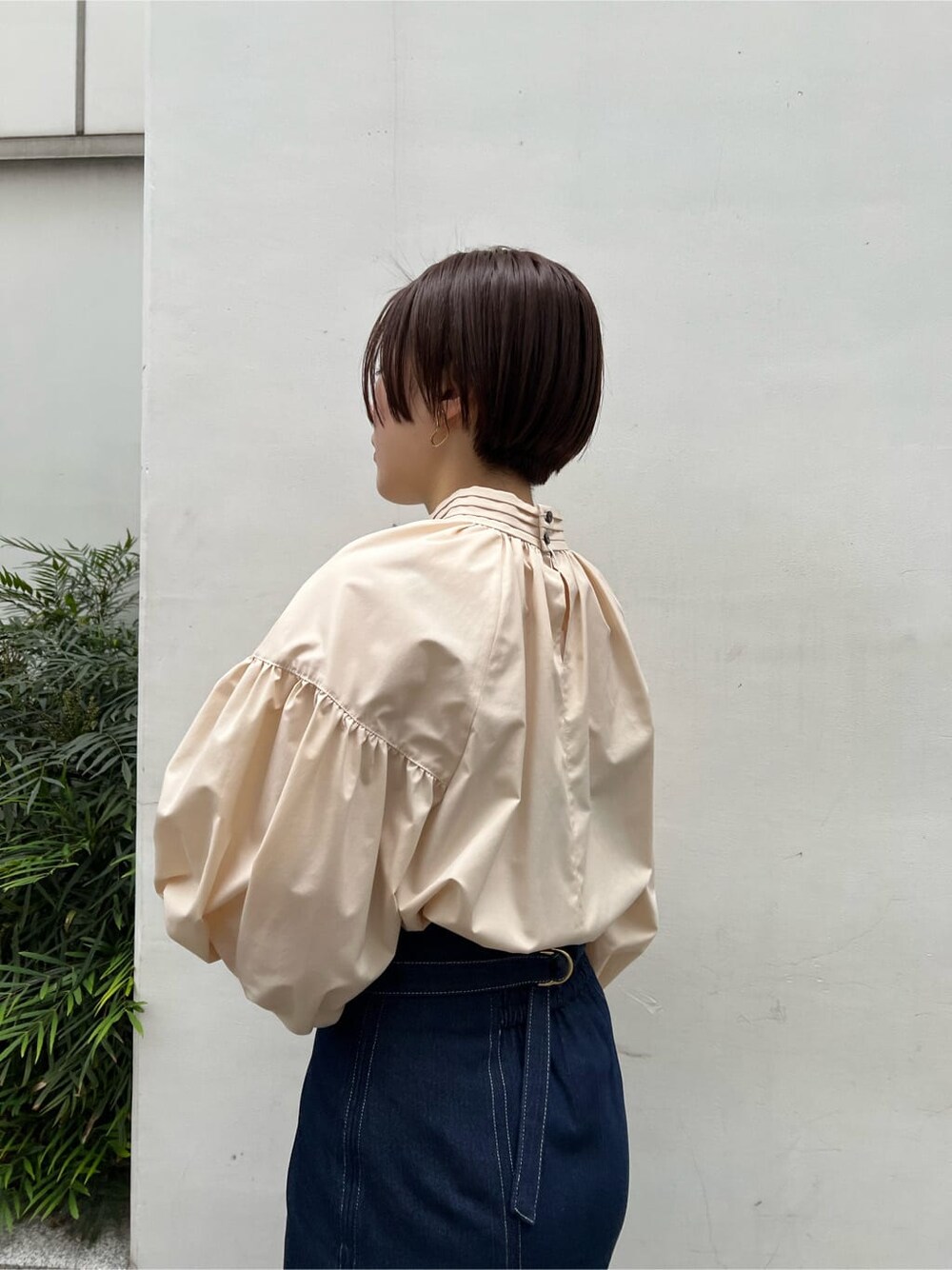 ベージュ系のシャツ/ブラウス、ベージュ系のブーツ、ブルー系のスカートを着用したレディースの春コーディネートの6枚目の写真