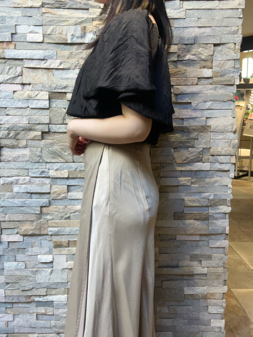 ブラック系のシャツ/ブラウス、ベージュ系のスカート、ホワイト系のサンダルを着用したレディースの夏コーディネートの5枚目の写真