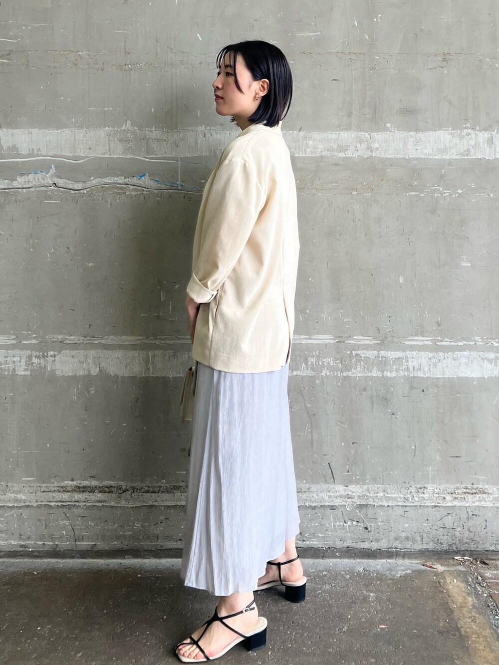 ブラック系のサンダル、ホワイト系のショルダーバッグ、ベージュ系のテーラードジャケットを着用したレディースの春コーディネートの2枚目の写真