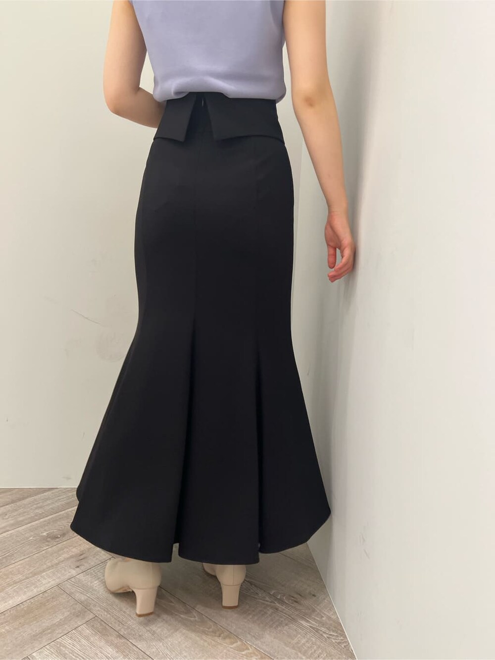 ホワイト系のパンプス、ブラック系のスカート、パープル系のニット/セーターを着用したレディースの夏コーディネートの7枚目の写真