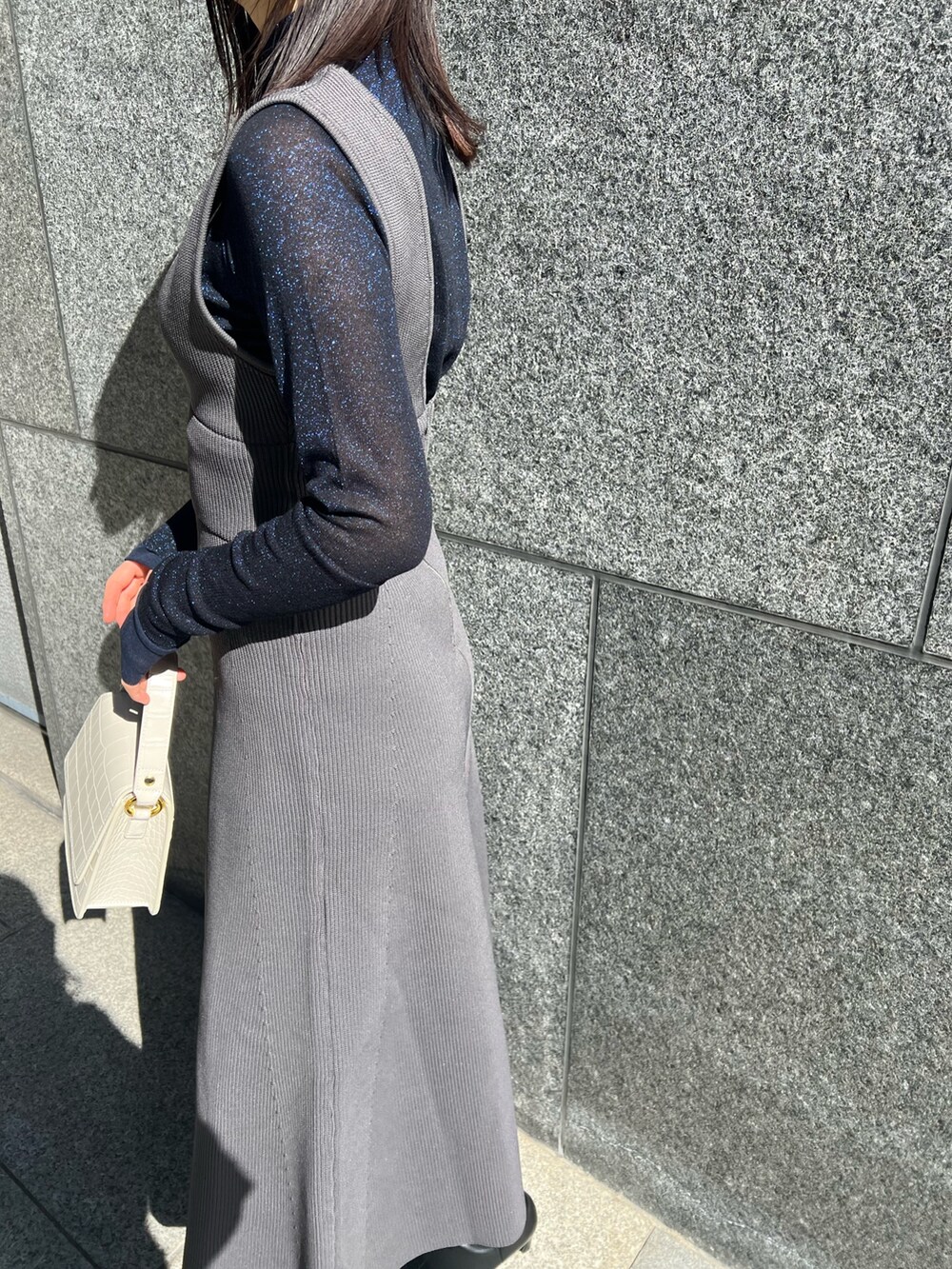 グレー系のTシャツ/カットソー、グレー系のカーディガン/ボレロ、グレー系のジャンパースカートを着用したレディースの秋コーディネートの4枚目の写真