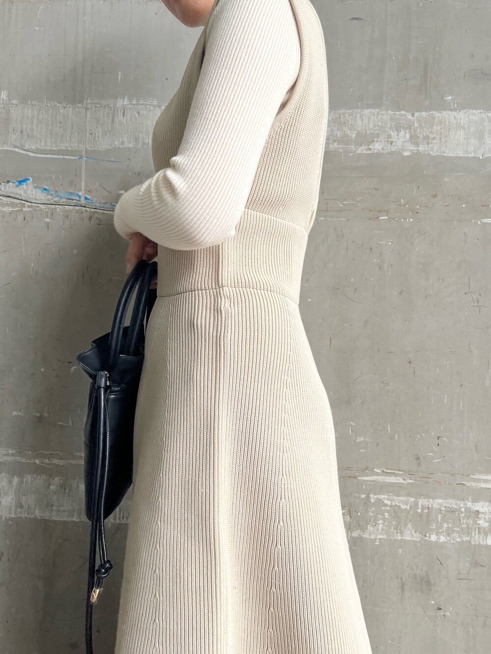 ベージュ系のブーツ、ブラック系のハンドバッグ、ホワイト系のニット/セーターを着用したレディースの秋コーディネートの10枚目の写真