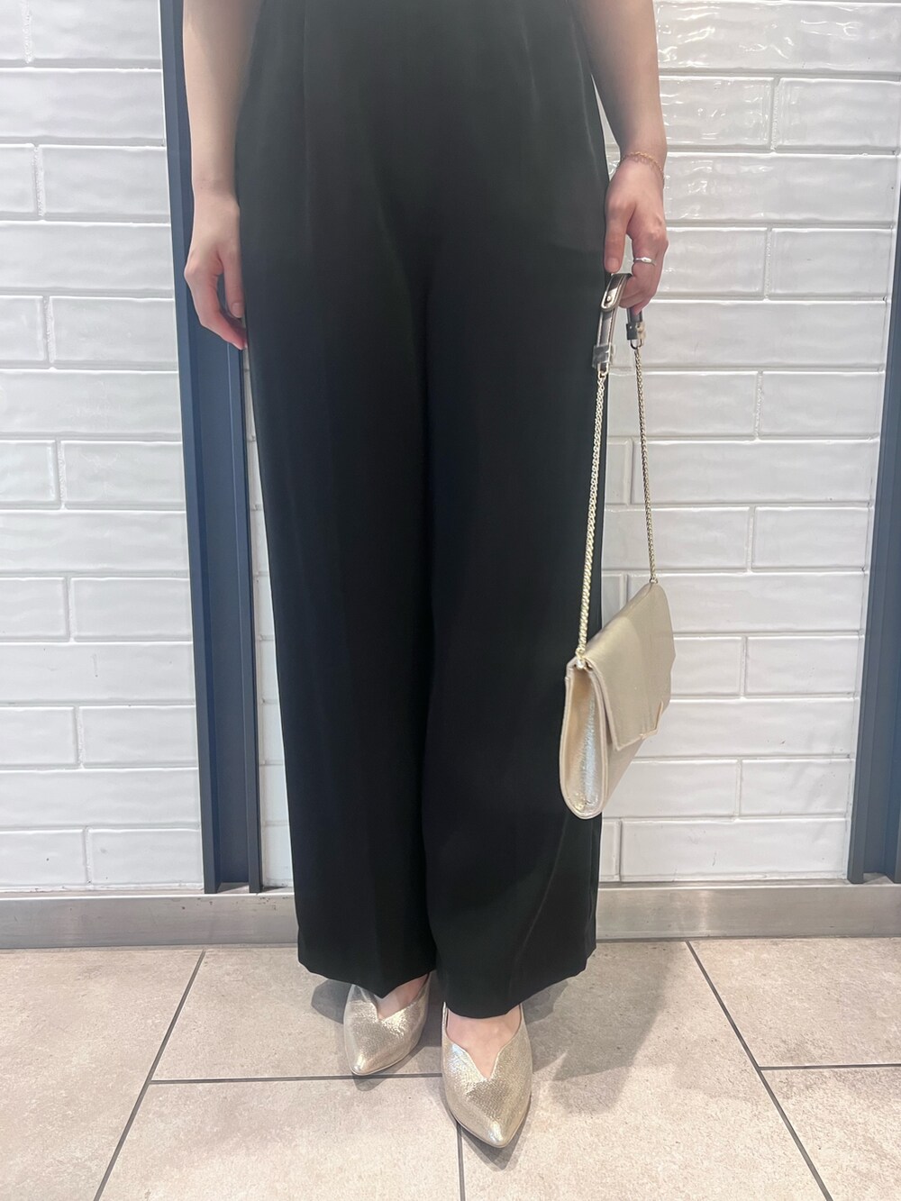 その他のパンツドレス、ゴールド系のパンプス、ゴールド系のクラッチバッグを着用したレディースの春コーディネートの6枚目の写真