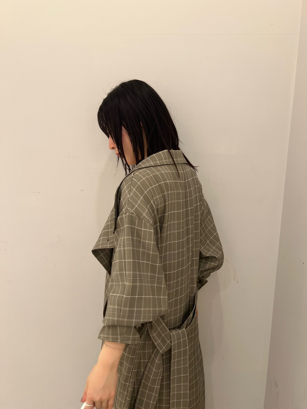 グレー系のチェスターコート、ブルー系のデニムパンツ、ホワイト系のニット/セーターを着用したレディースの春コーディネートの4枚目の写真