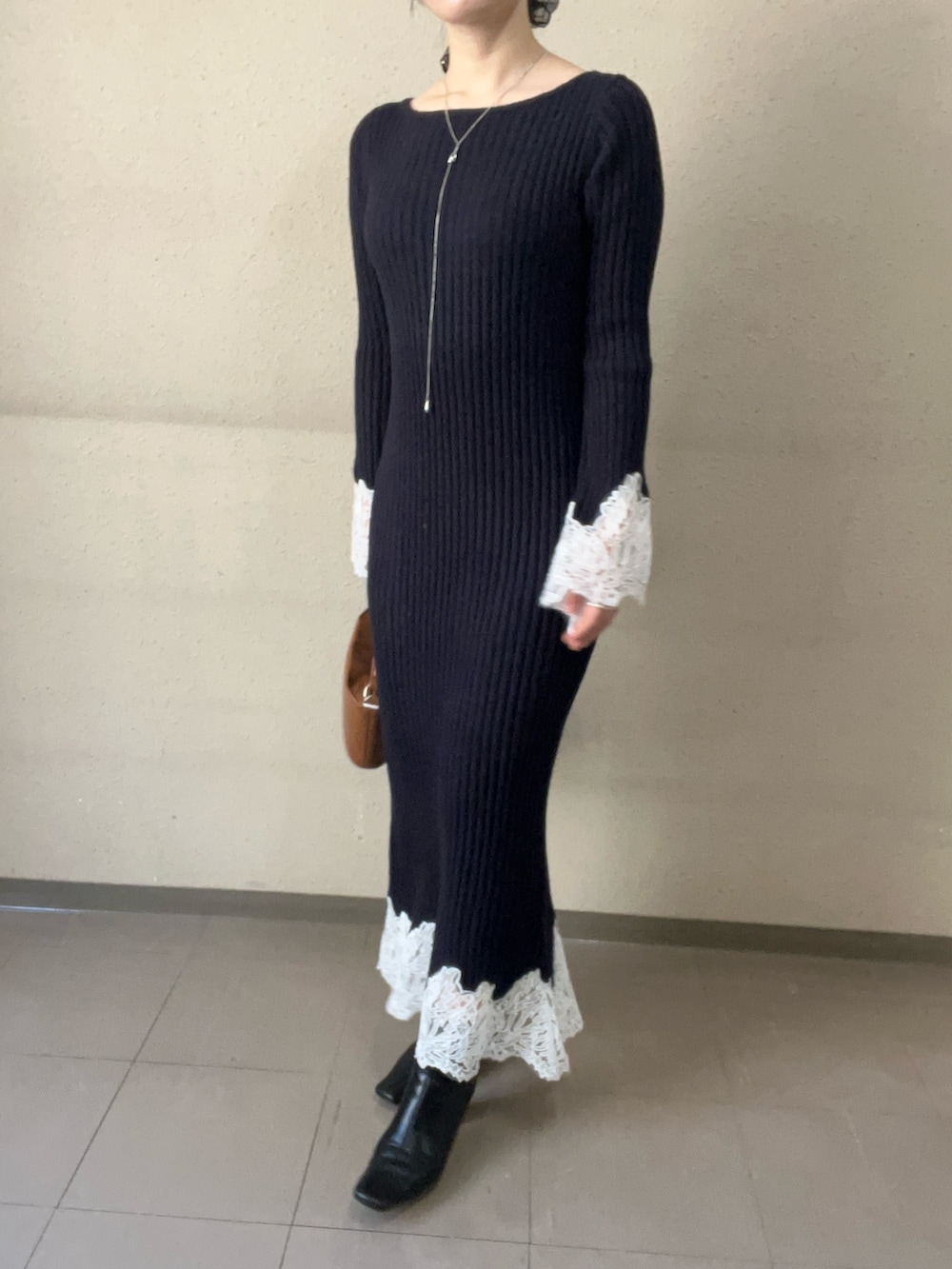 イエロー系のハンドバッグ、ブルー系のワンピース、ブラック系のブーツを着用したレディースの秋コーディネートの6枚目の写真