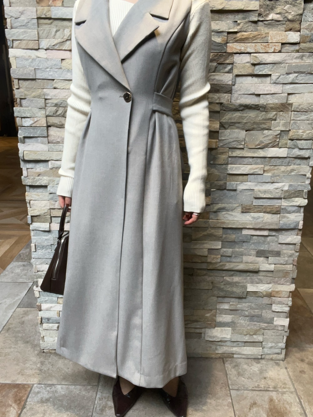 ブラウン系のパンプス、グレー系のワンピース、ホワイト系のニット/セーターを着用したレディースの秋コーディネートの5枚目の写真