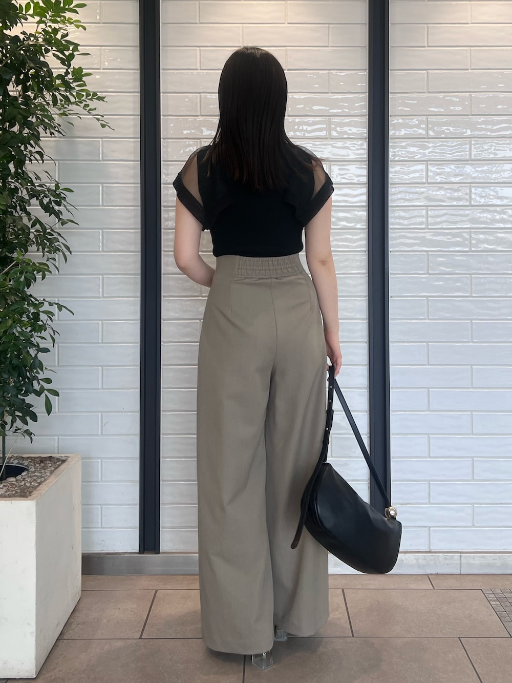 ブラウン系のその他パンツ、ブラック系のニット/セーター、ブラック系のサンダルを着用したレディースの春コーディネートの3枚目の写真