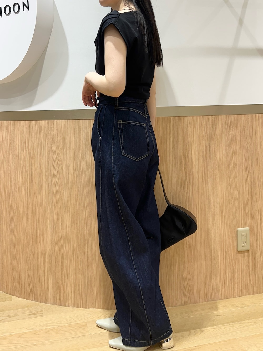 ブルー系のデニムパンツ、グリーン系のパンプス、ブラック系のTシャツ/カットソーを着用したレディースの春コーディネートの4枚目の写真
